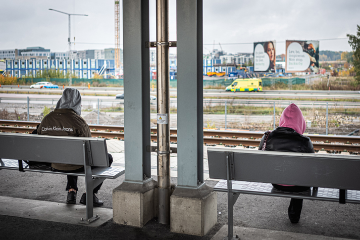 två personer på varsin bänk